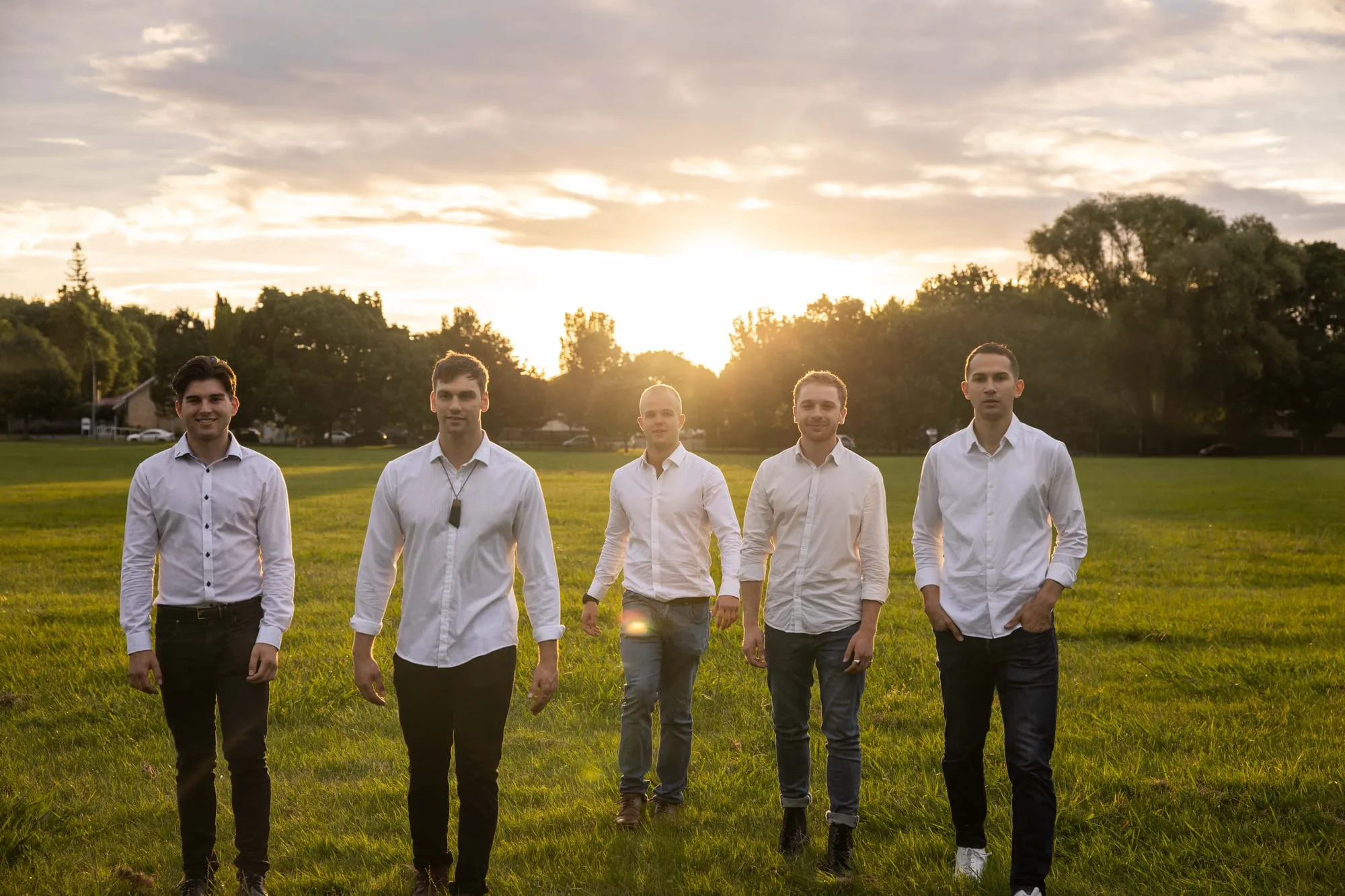 The Flourish team walking towards the camera across a park at sunset